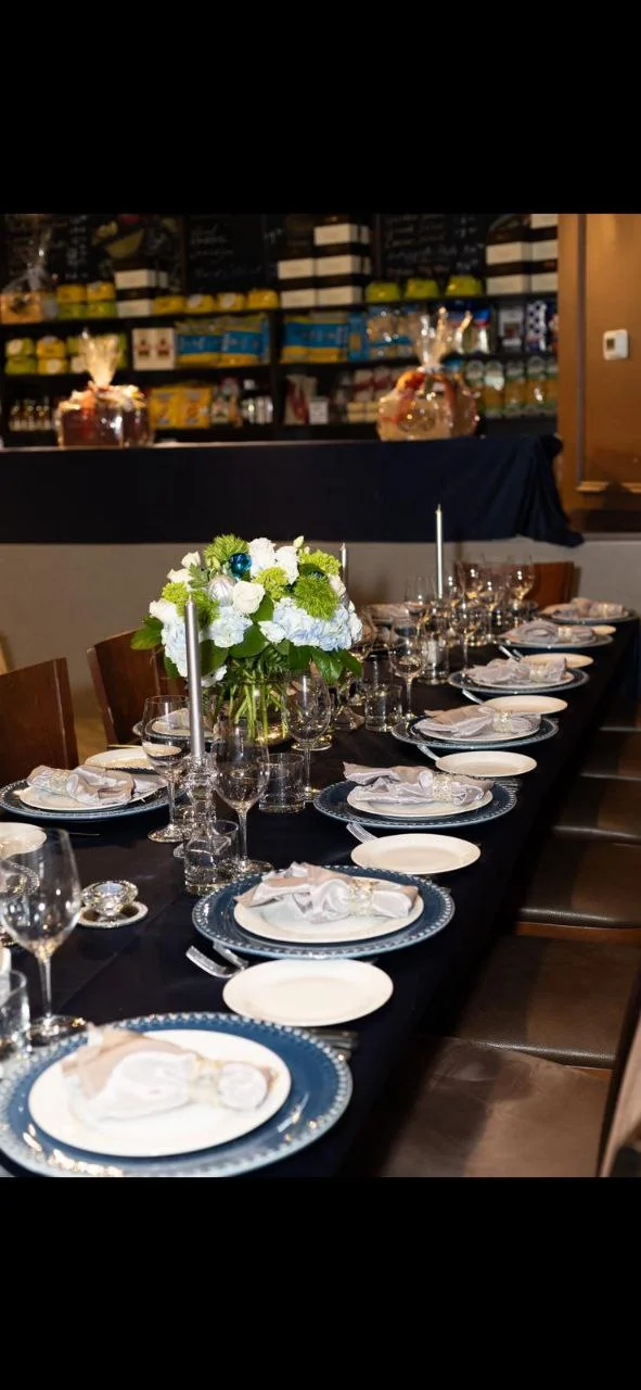 Table at Giorgio D set for an event with blue linens and fresh flowers